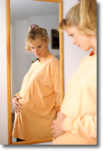 pregnant woman looking in mirror